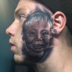 Счастливый отец сделал татуировку с портретом сына на своем лице